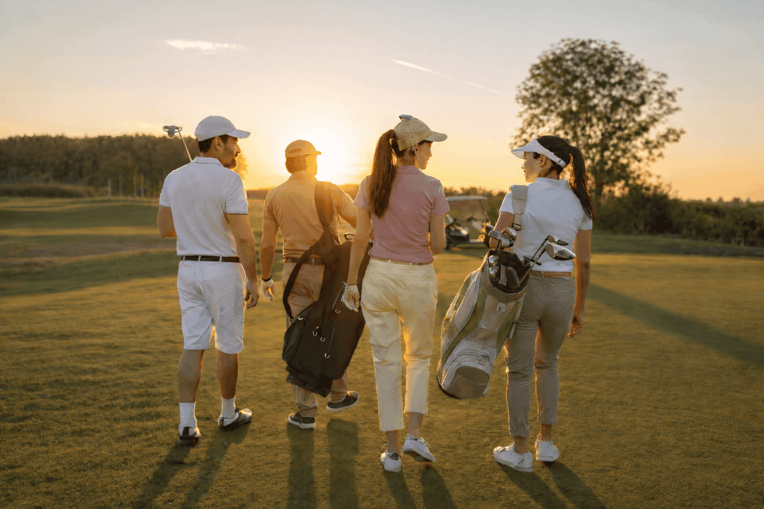 ゴルフ仲間と夕日のコースを歩く